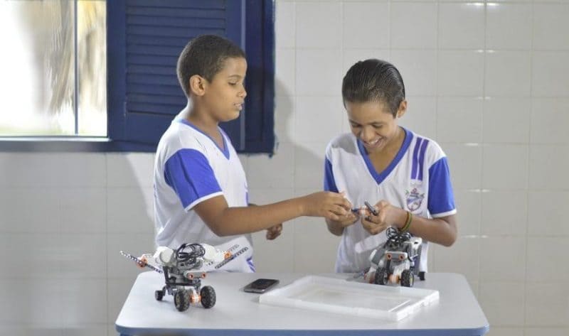 Imagem de duas crianças brincando com um robô